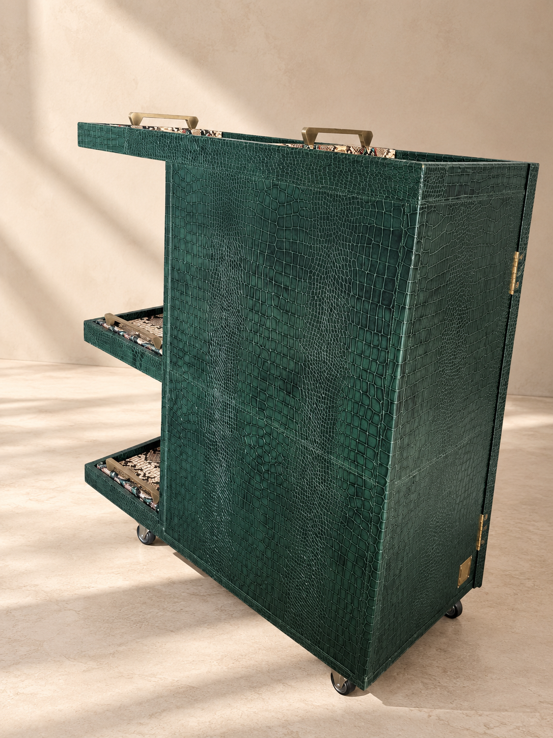 Back view of the Panjim Leather Rolling Bar Cabinet showing the full croc-embossed leather wrap, three stacked serving trays with brass handles and castors — Art Avenue, made to order