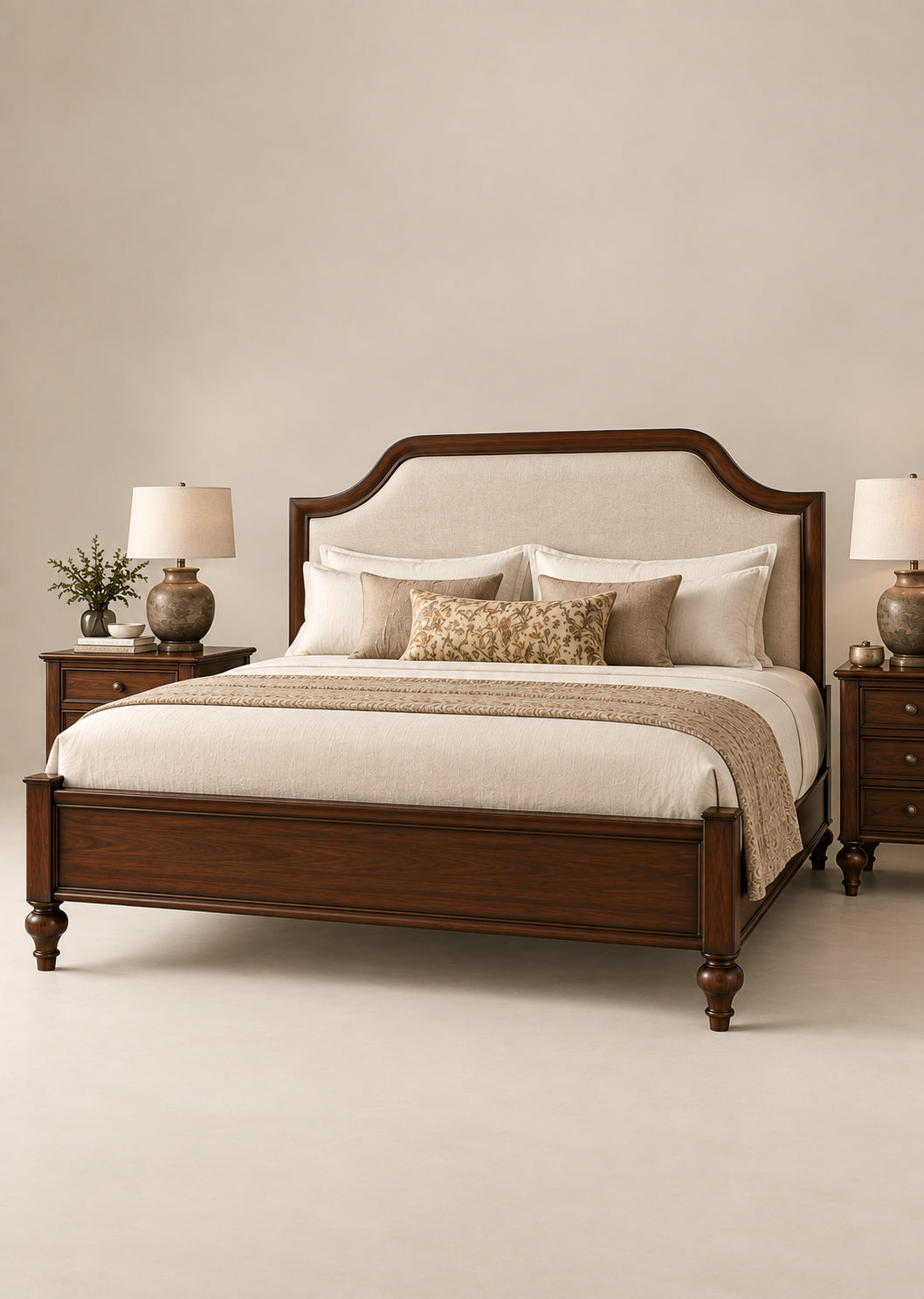 Darjeeling Colonial Bed with upholstered headboard in ivory linen — arched Walnut frame, low panelled footboard and turned feet, beside matching three-drawer bedside tables. Art Avenue, made to order.