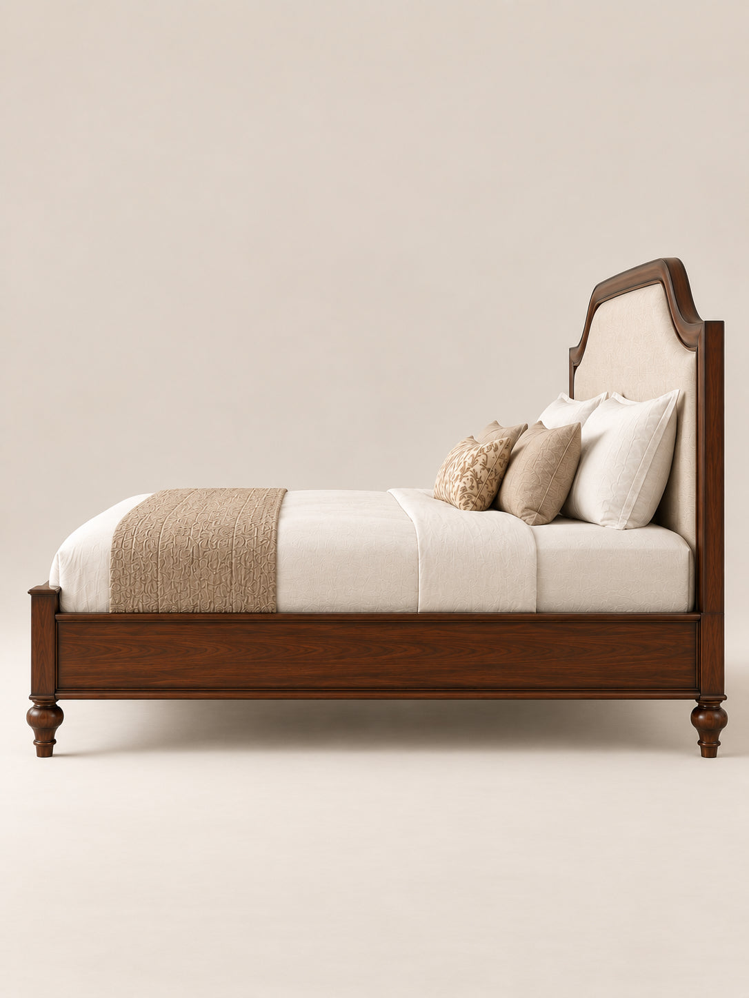 Darjeeling Colonial Bed with upholstered headboard in side profile — ivory linen panel in an arched Walnut frame, moulded side rail and turned feet. Art Avenue, made to order.