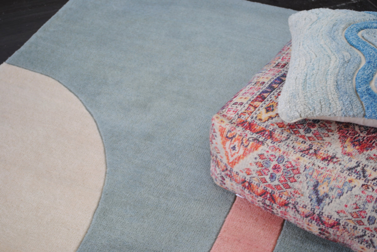 Close view of the Pondicherry rug where the ivory arch meets the sea-glass blue field, showing the carved line at the colour change, hand-tufted New Zealand wool, Art Avenue