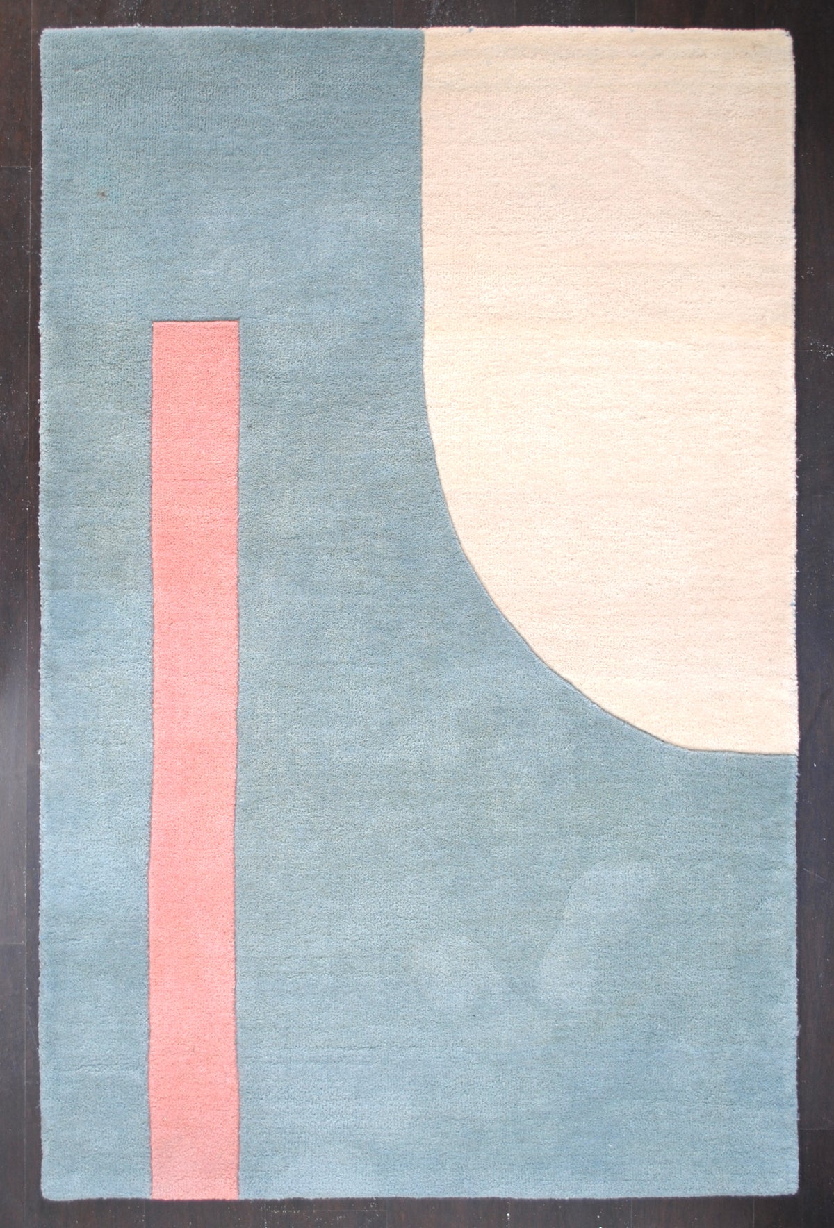 Pondicherry hand-tufted wool rug laid flat on a dark floor, ivory arch and coral bar on a sea-glass blue field, Art Avenue, 4×6 ft