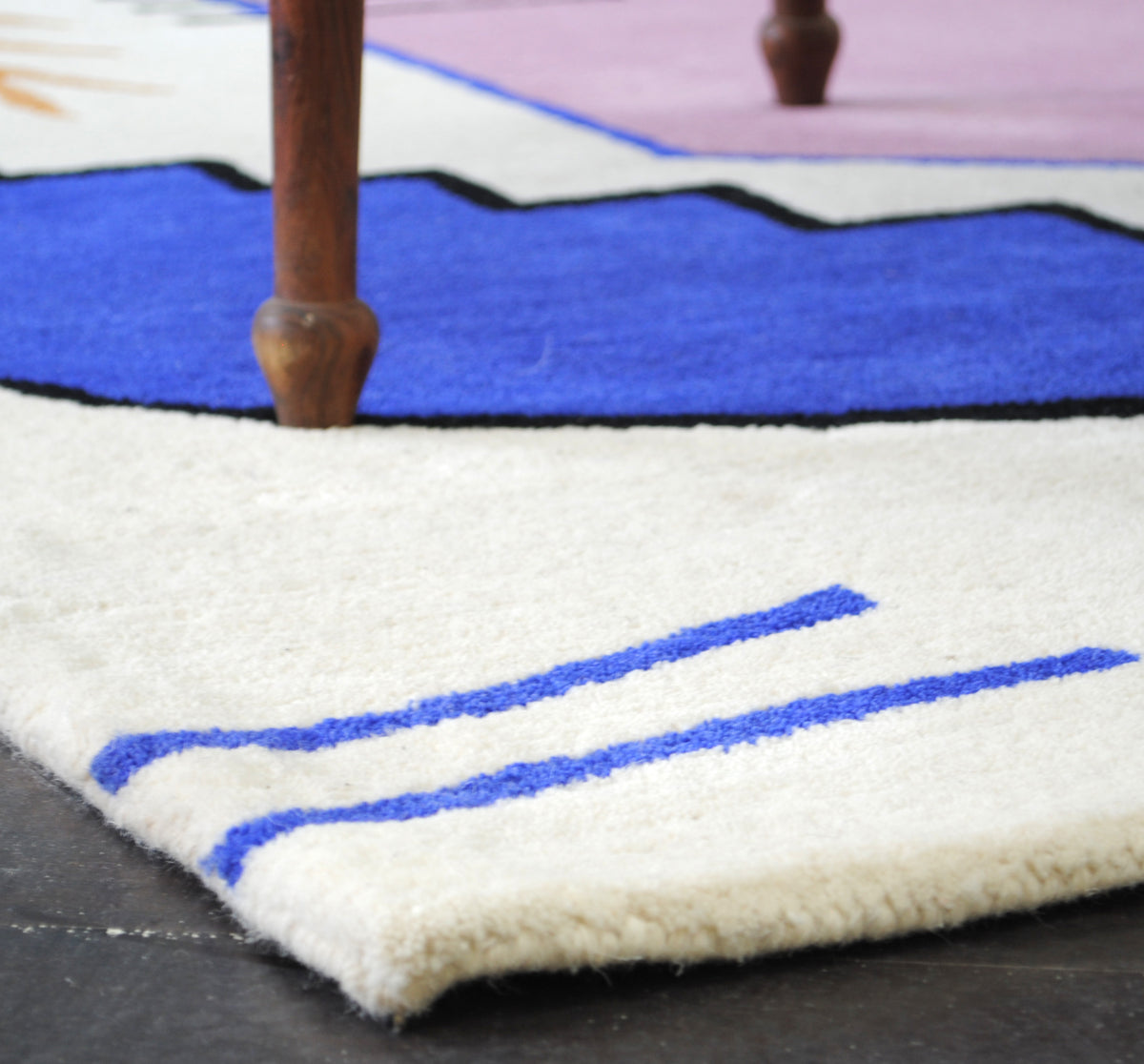 Low view across the ivory edge of the Hampi hand-tufted rug, showing the depth of the New Zealand wool pile and the bound edge, Art Avenue