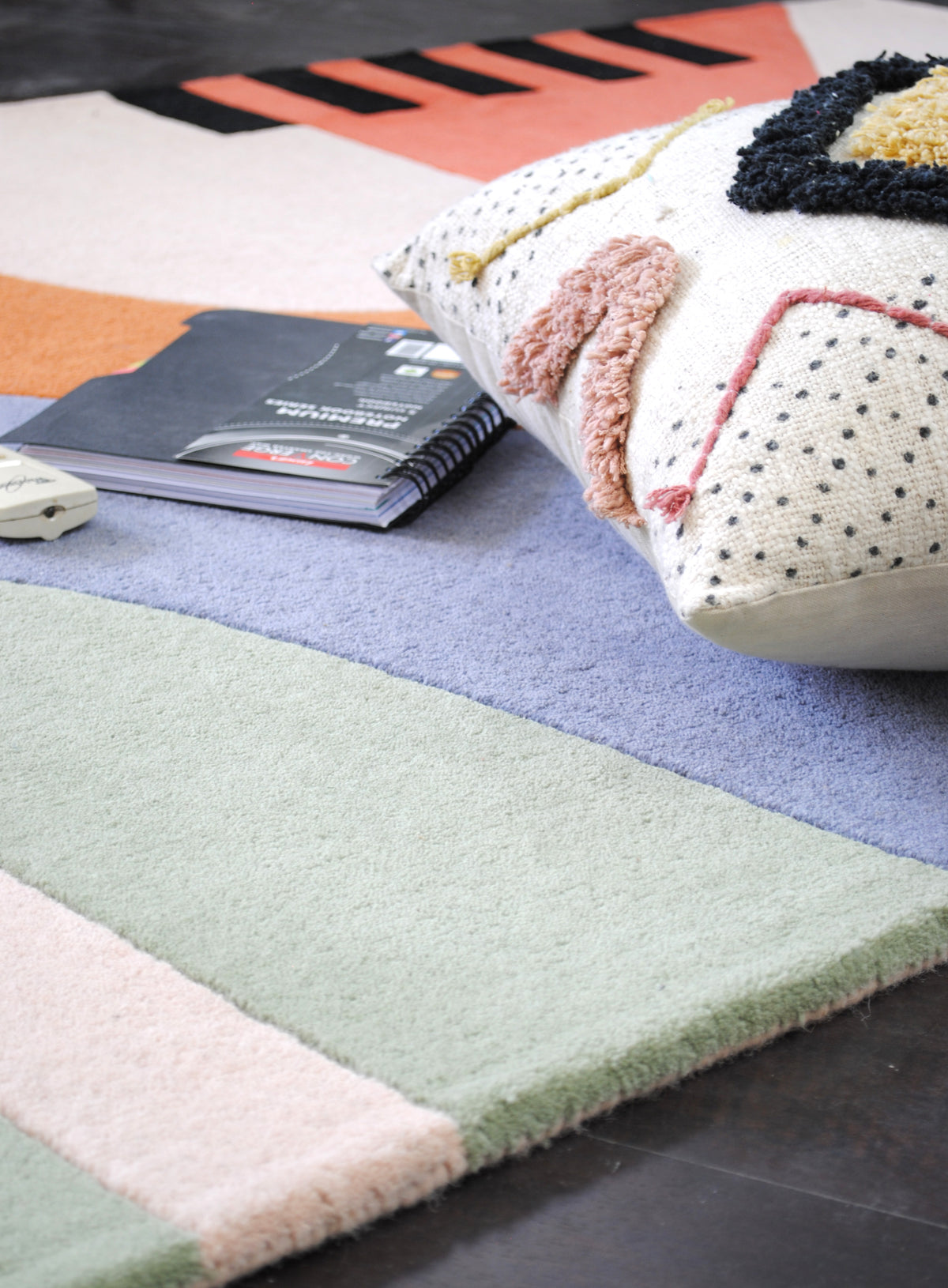Close view of the Goa rug's mint, lilac-blue and blush wool pile, carved channels between colours and bound edge, Art Avenue
