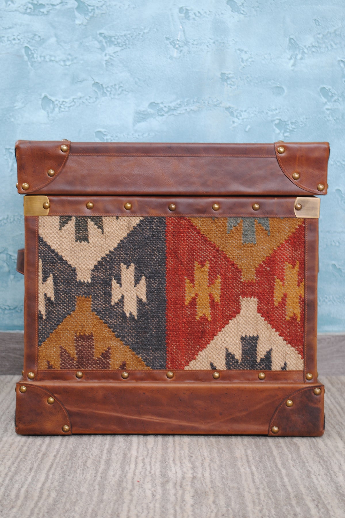 Front elevation of the Madras kilim trunk showing the handwoven kilim panel and leather binding