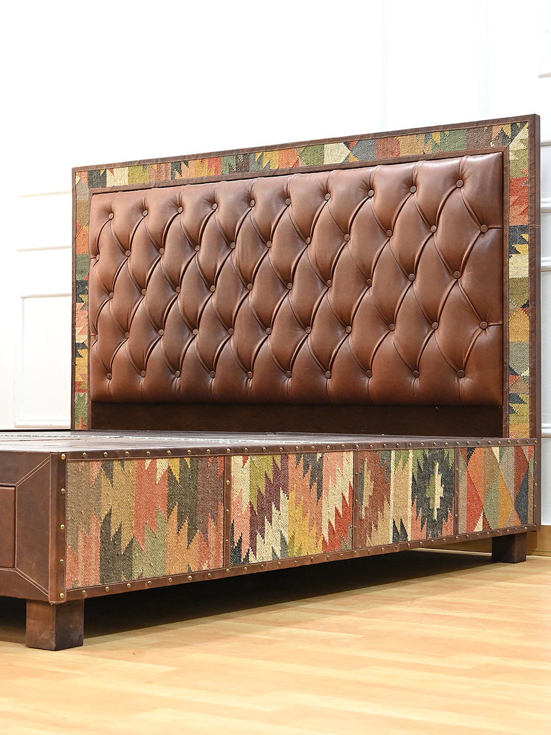 Narlai kilim and leather storage bed by Art Avenue, made to order — three-quarter view showing the vintage kilim side panel