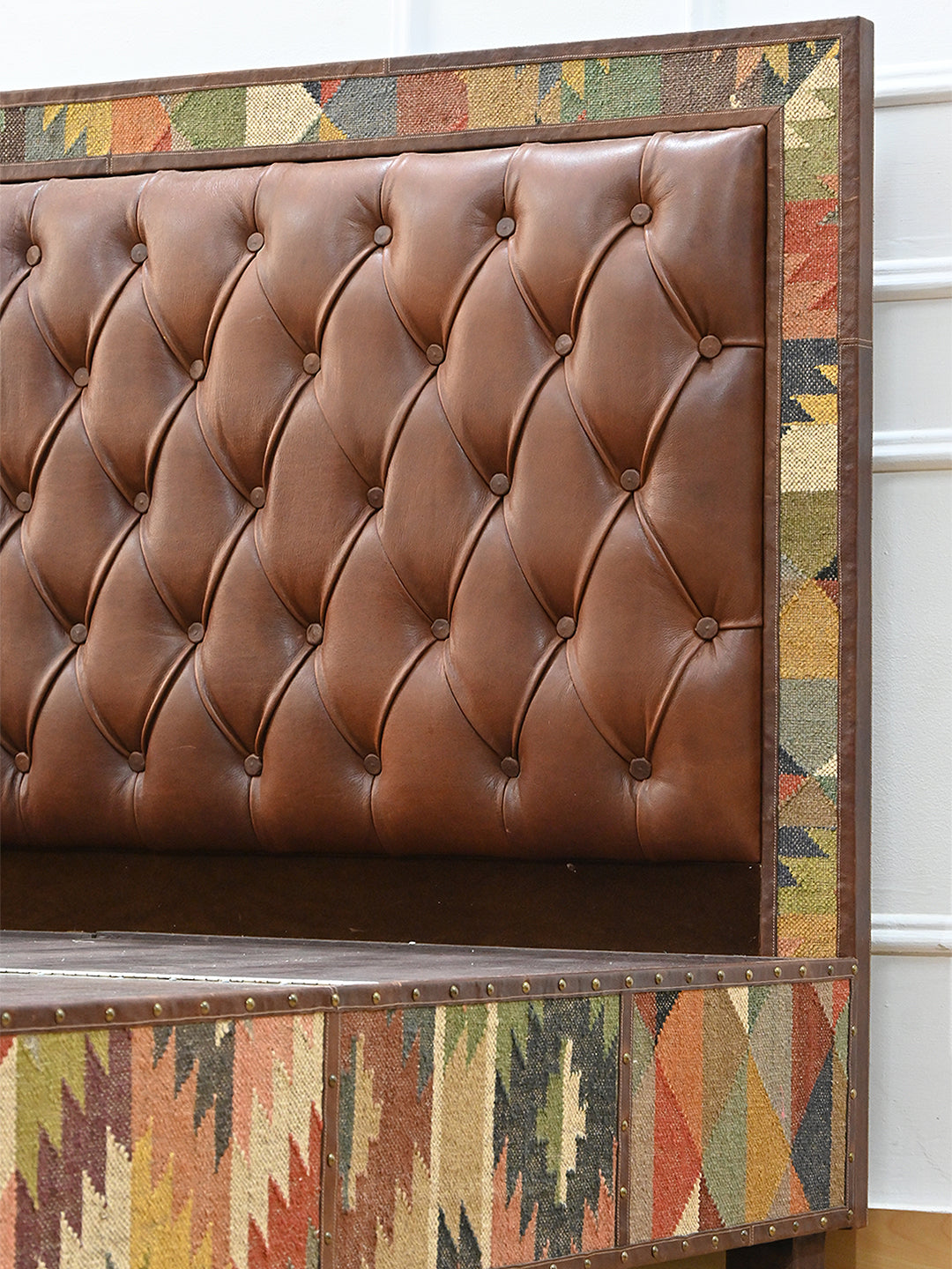 Narlai kilim and leather storage bed by Art Avenue, made to order — detail of the kilim headboard border and leather buttoning