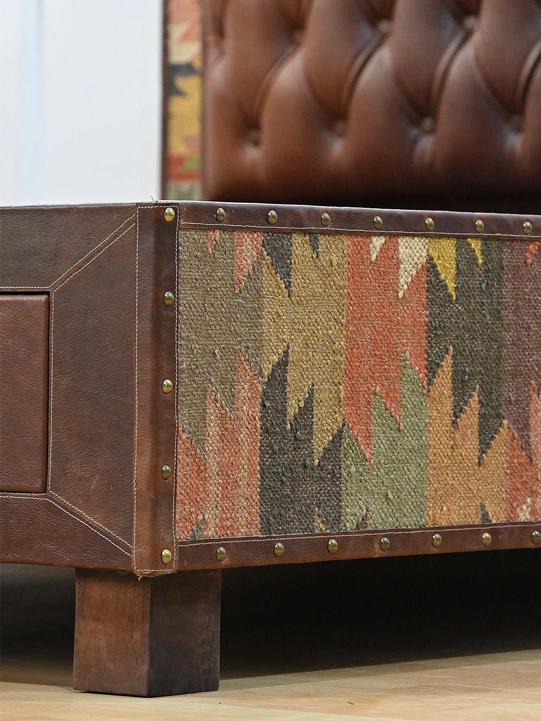 Narlai kilim and leather storage bed by Art Avenue, made to order — detail of kilim side panel, brass studs and solid wood leg