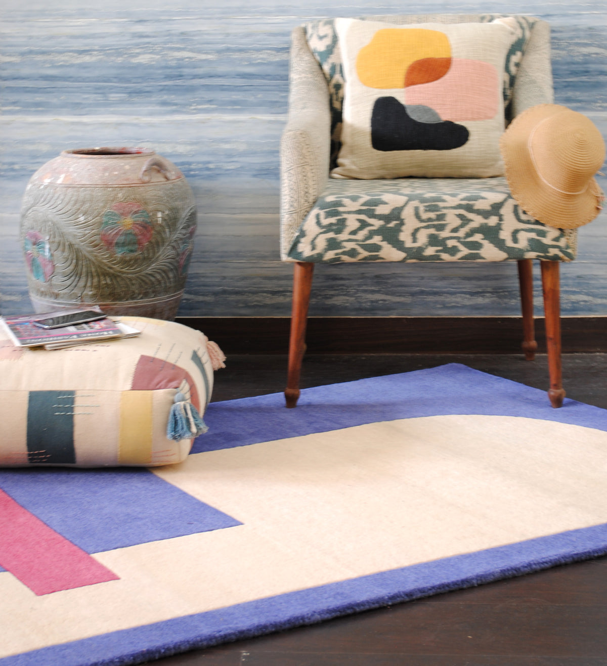 Mahe rug in a styled room with an ikat armchair and patchwork floor cushion