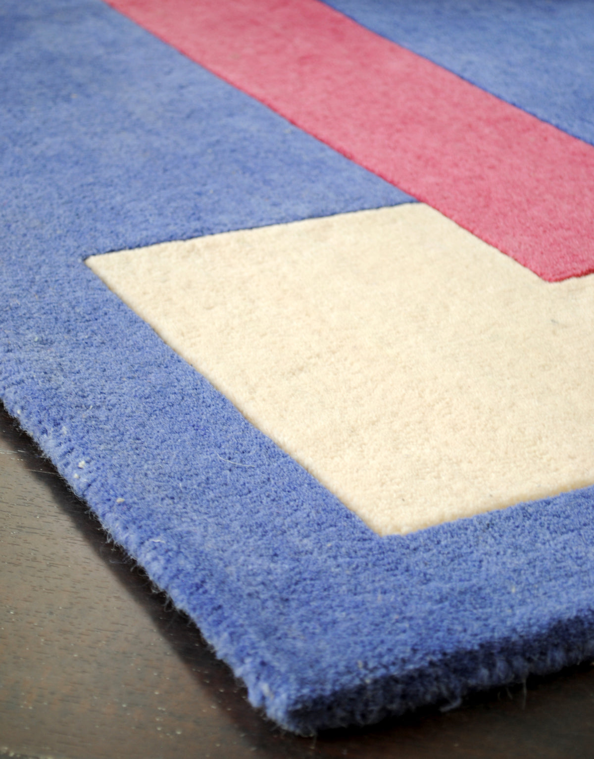Carved pile outlining the ivory and raspberry shapes on the Mahe rug