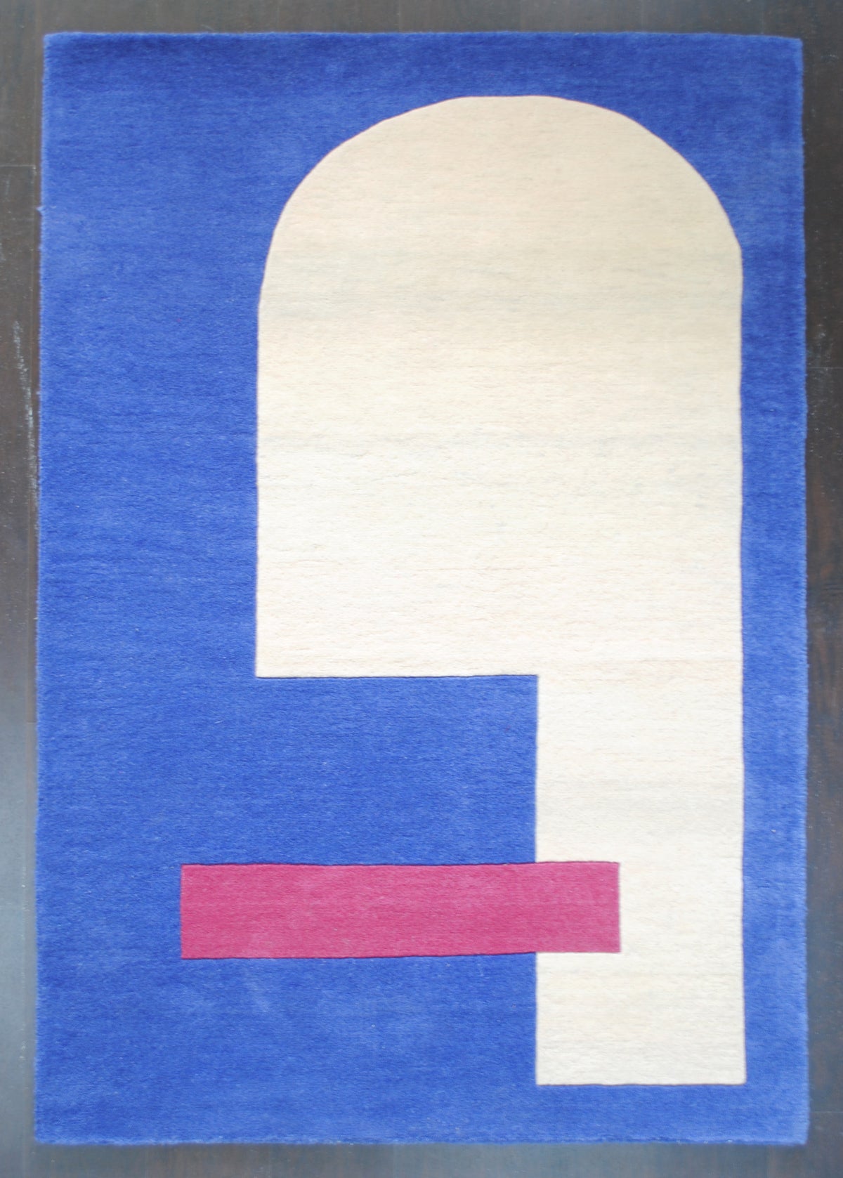 Mahe rug laid flat, showing the ivory arch stepping into a column along one side