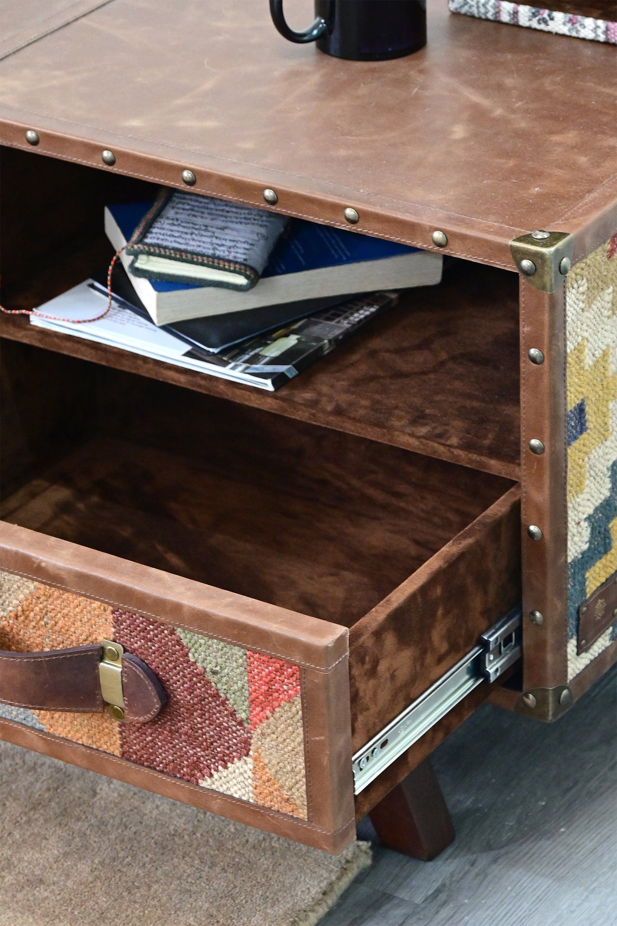 Drawer of the Ranakpur TV unit pulled open on its runner, suede-lined interior below a shelf and brass corner cap
