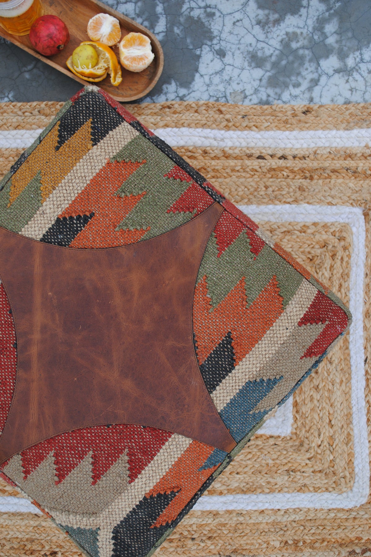 Angled overhead view of the hand-cut leather medallion stitched into the kilim seat