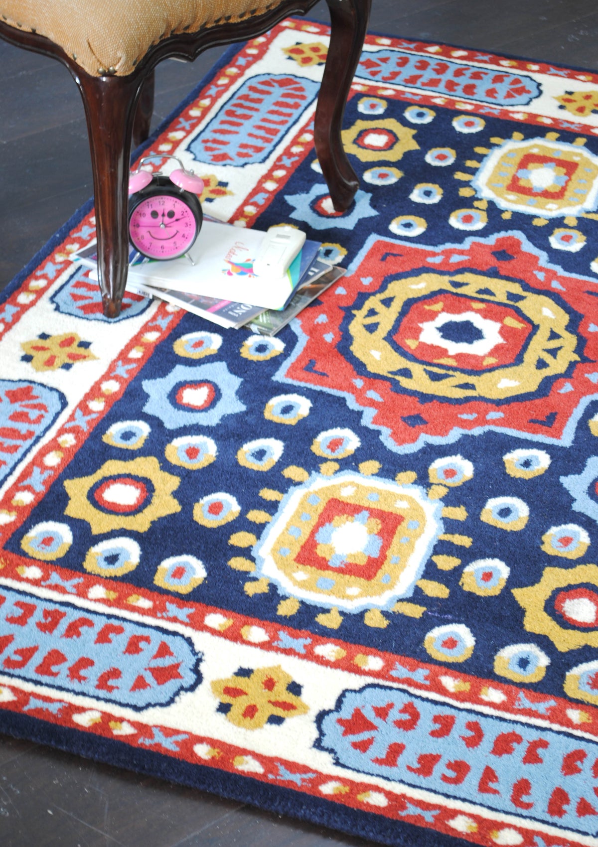 Angled view of the Orchha rug showing the red star medallion, gold medallions and ikat-style roundels