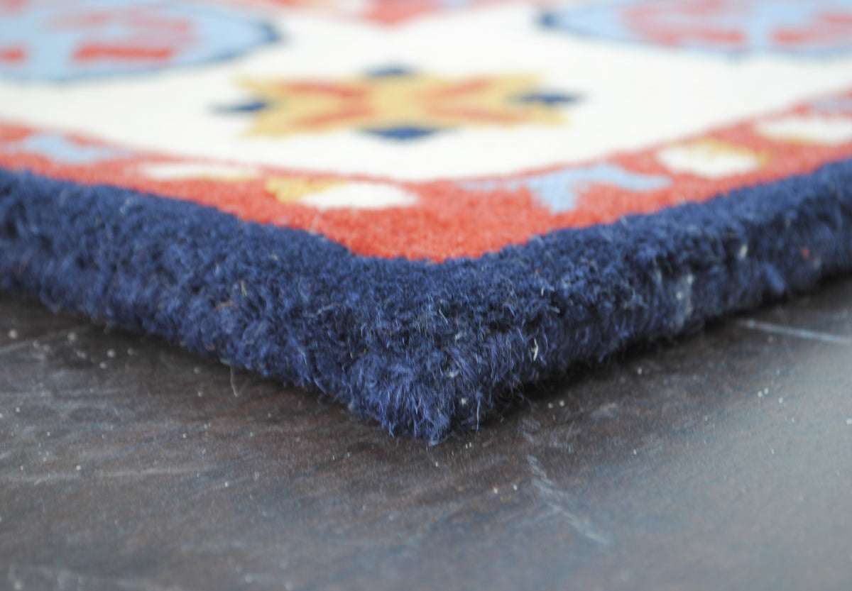 Corner of the Orchha rug showing pile depth and the navy wool edge, no fringe