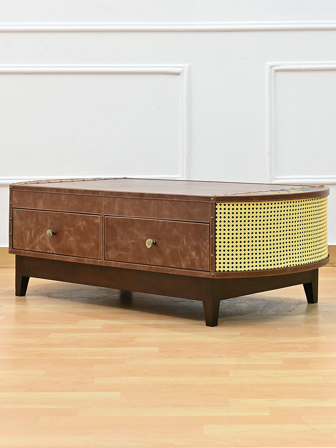 Bisalpur coffee table at three-quarter angle, curved cane end panel and leather drawer front
