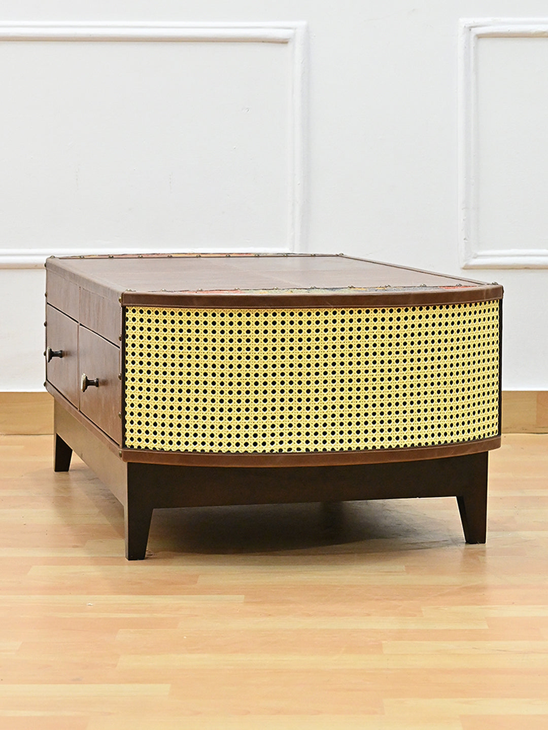 Angled end view of the Bisalpur coffee table showing the curve of the cane panel