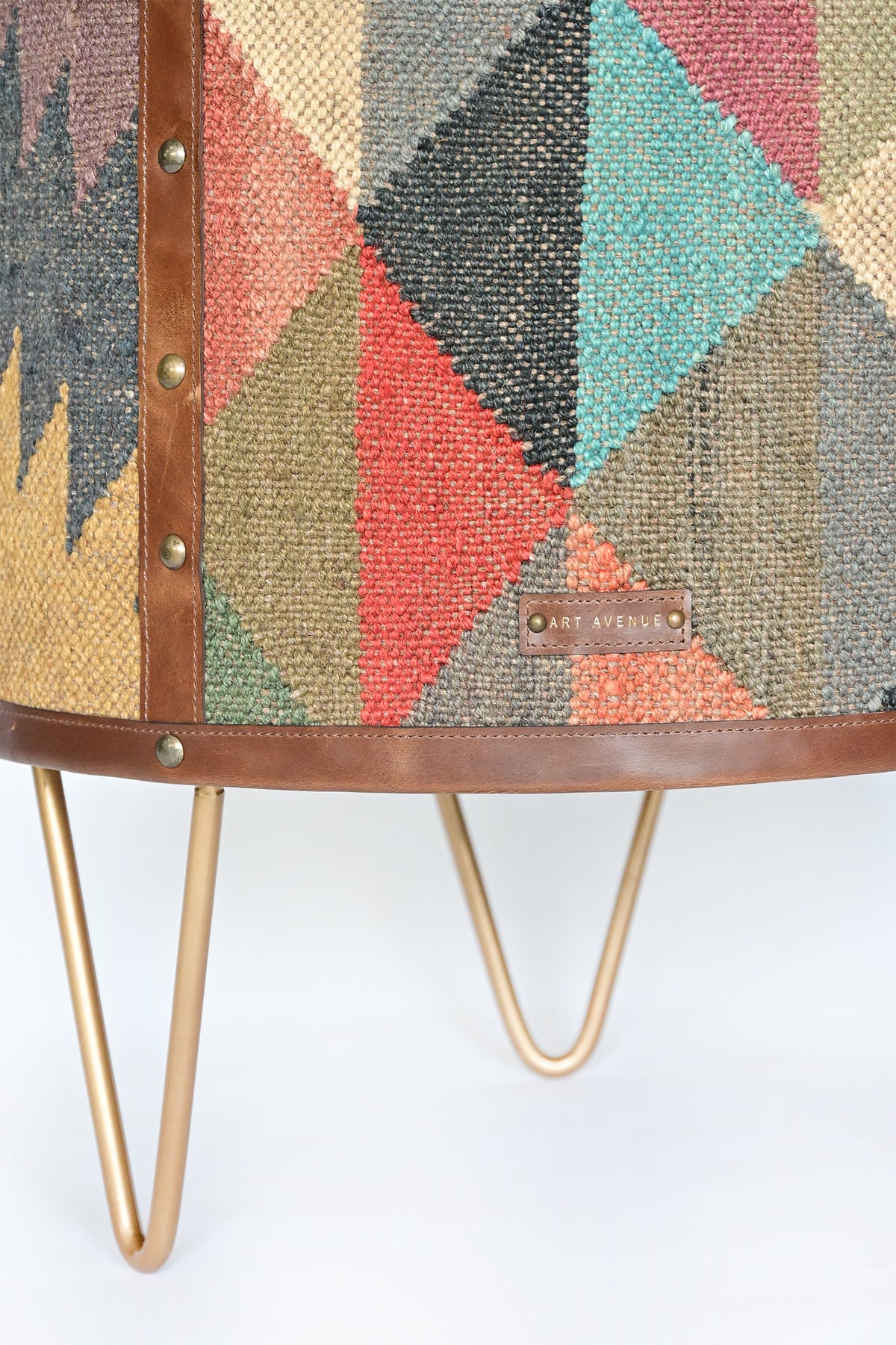 Alwar kilim side table detail: leather tag, studded strap and hairpin legs
