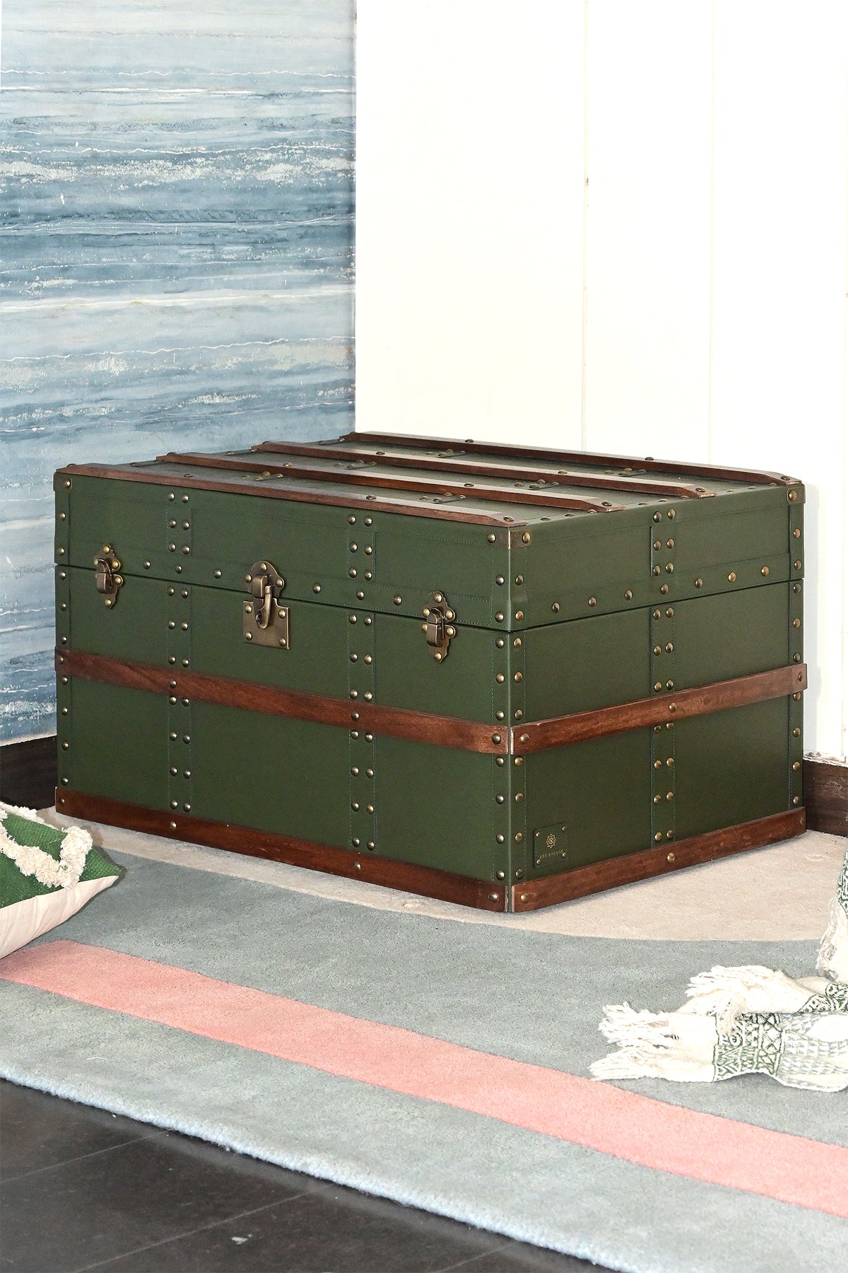 Leather steamer trunk against a painted wall, angled view — Art Avenue