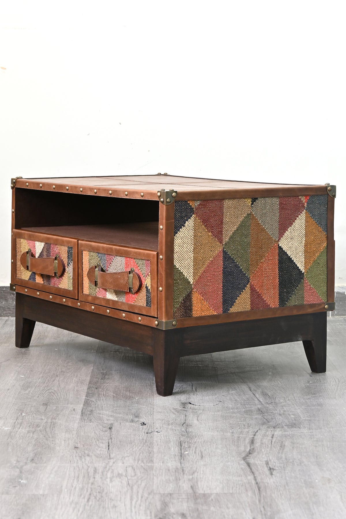 Barmer TV unit at a three-quarter angle, full-height vintage kilim panel on the flank and brass corner caps