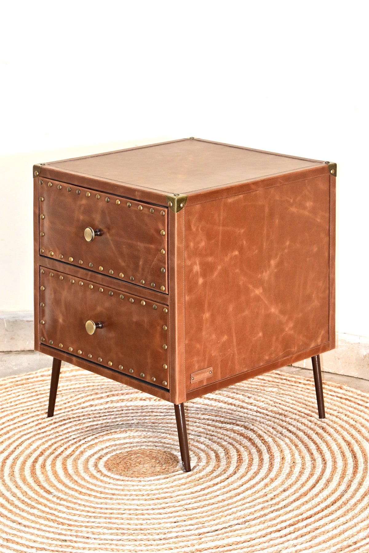 Kishangarh leather bedside table, three-quarter view showing marbled leather flank and brass corner caps, Art Avenue
