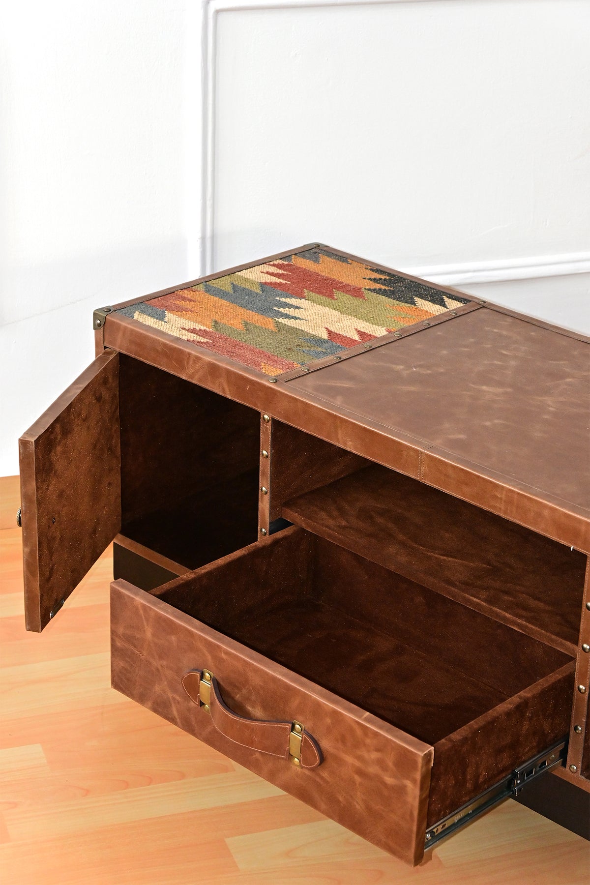 Open drawer and cupboard of the Karauli TV unit showing the suede lining and kilim top inset