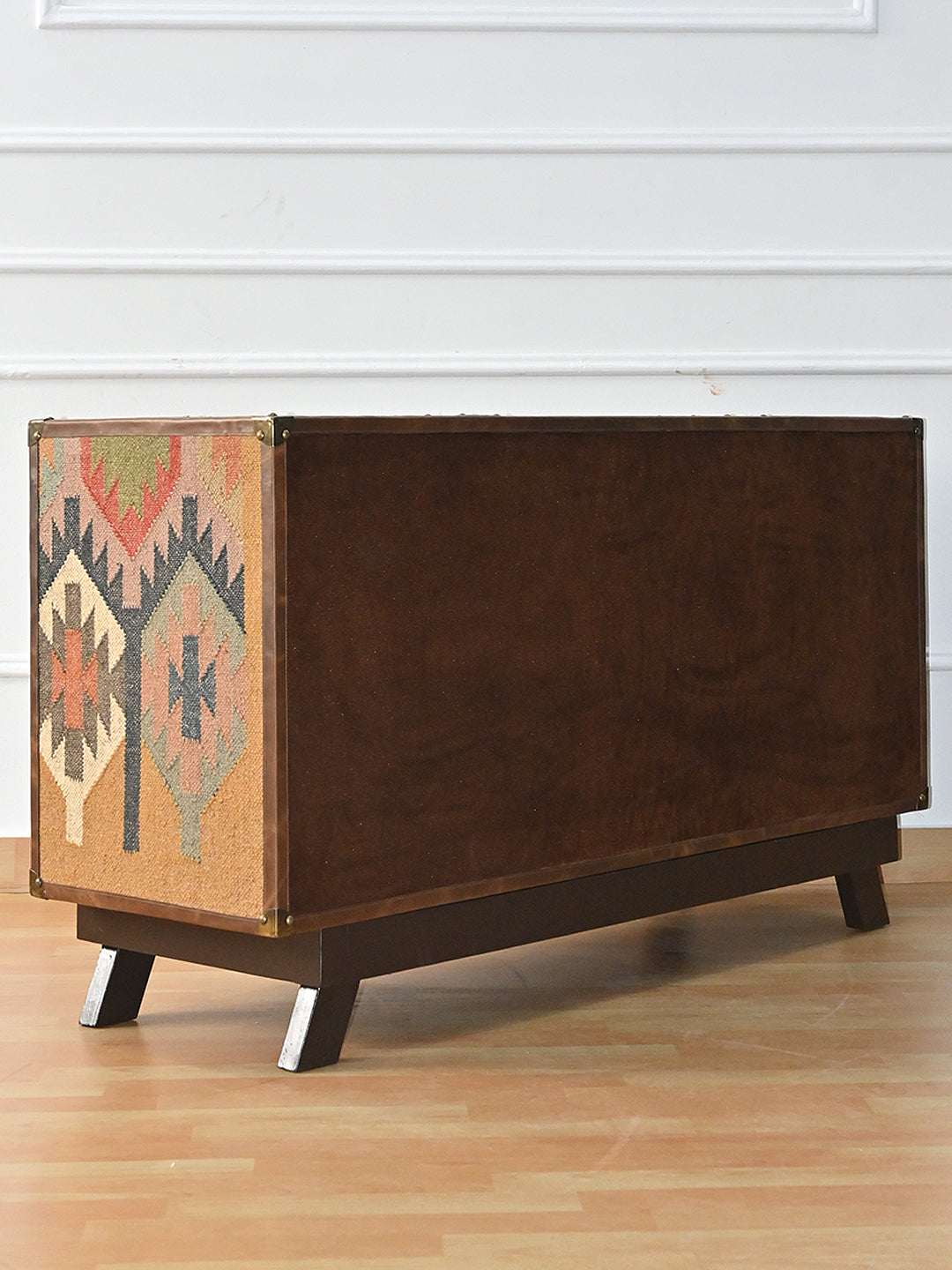 Back of the Mukundgarh TV unit, finished in suede with a leather border, on a solid wood plinth with splayed legs
