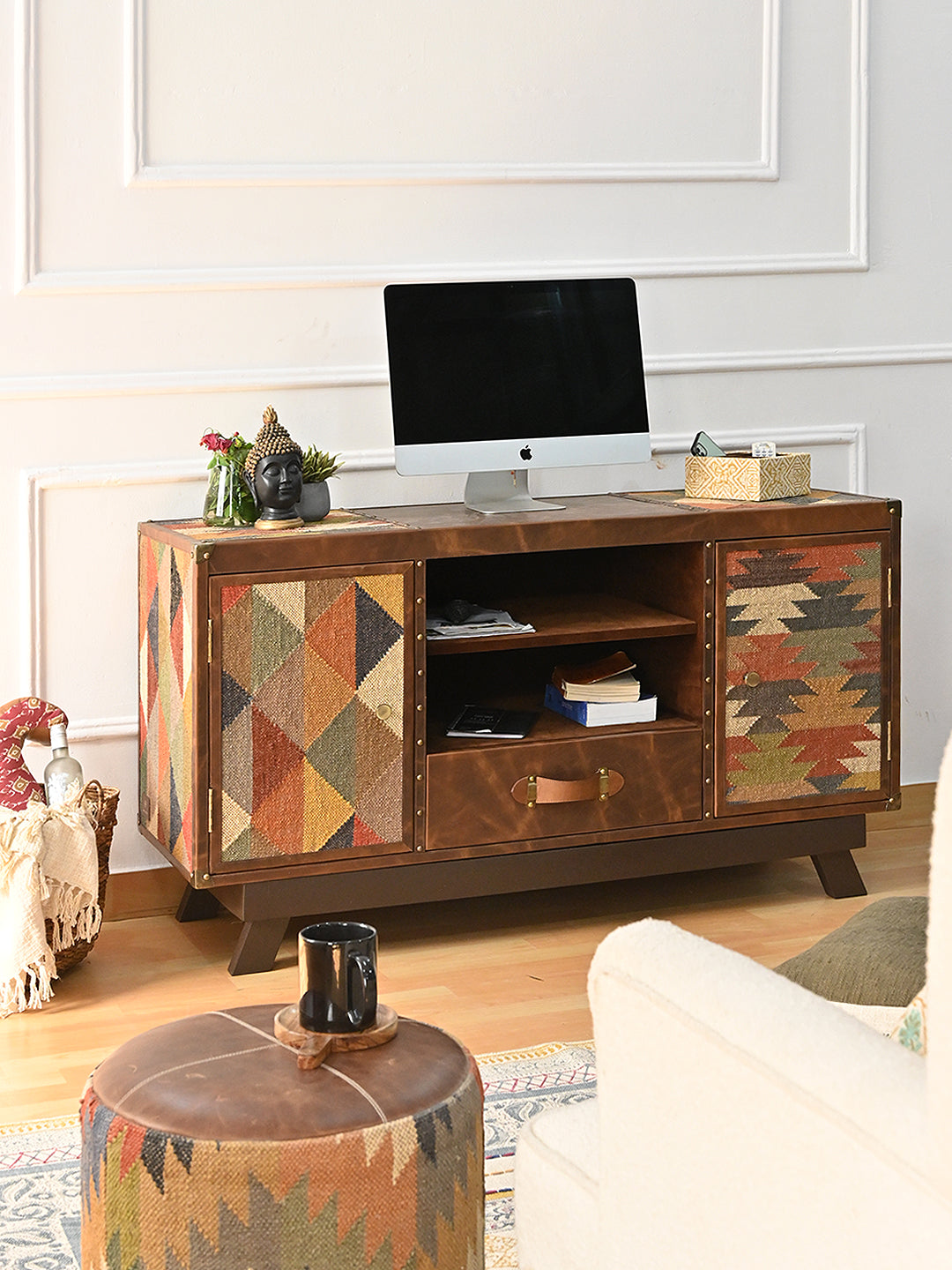 Mukundgarh kilim and leather media cabinet from the front with a desktop screen on its leather-and-kilim top and books on the open shelves