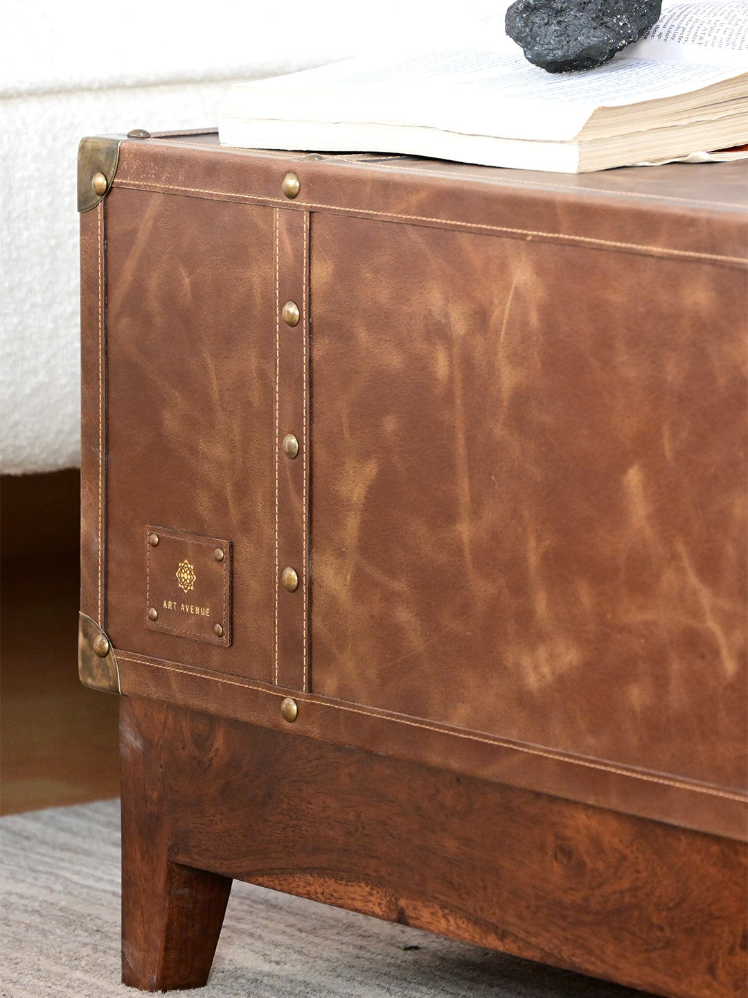 Nawalgarh leather trunk coffee table, close-up of the Art Avenue maker's tag and studded strap on distressed leather
