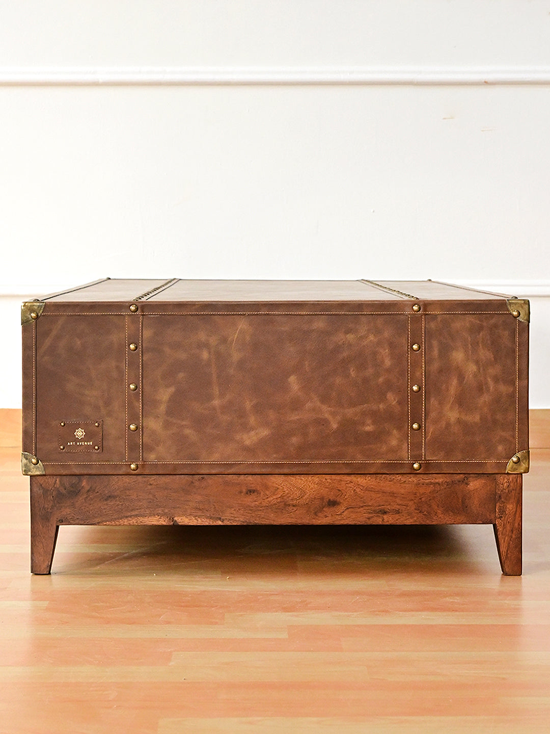 Nawalgarh leather trunk coffee table, end view with studded leather straps and shaped metal corner caps
