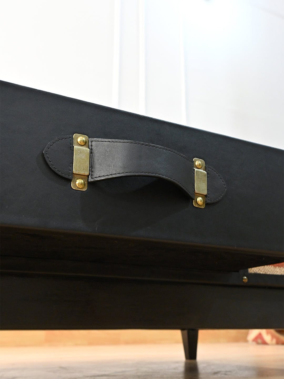 Saddle-stitched black leather strap handle on brass plates on the Kumbhalgarh drawer front