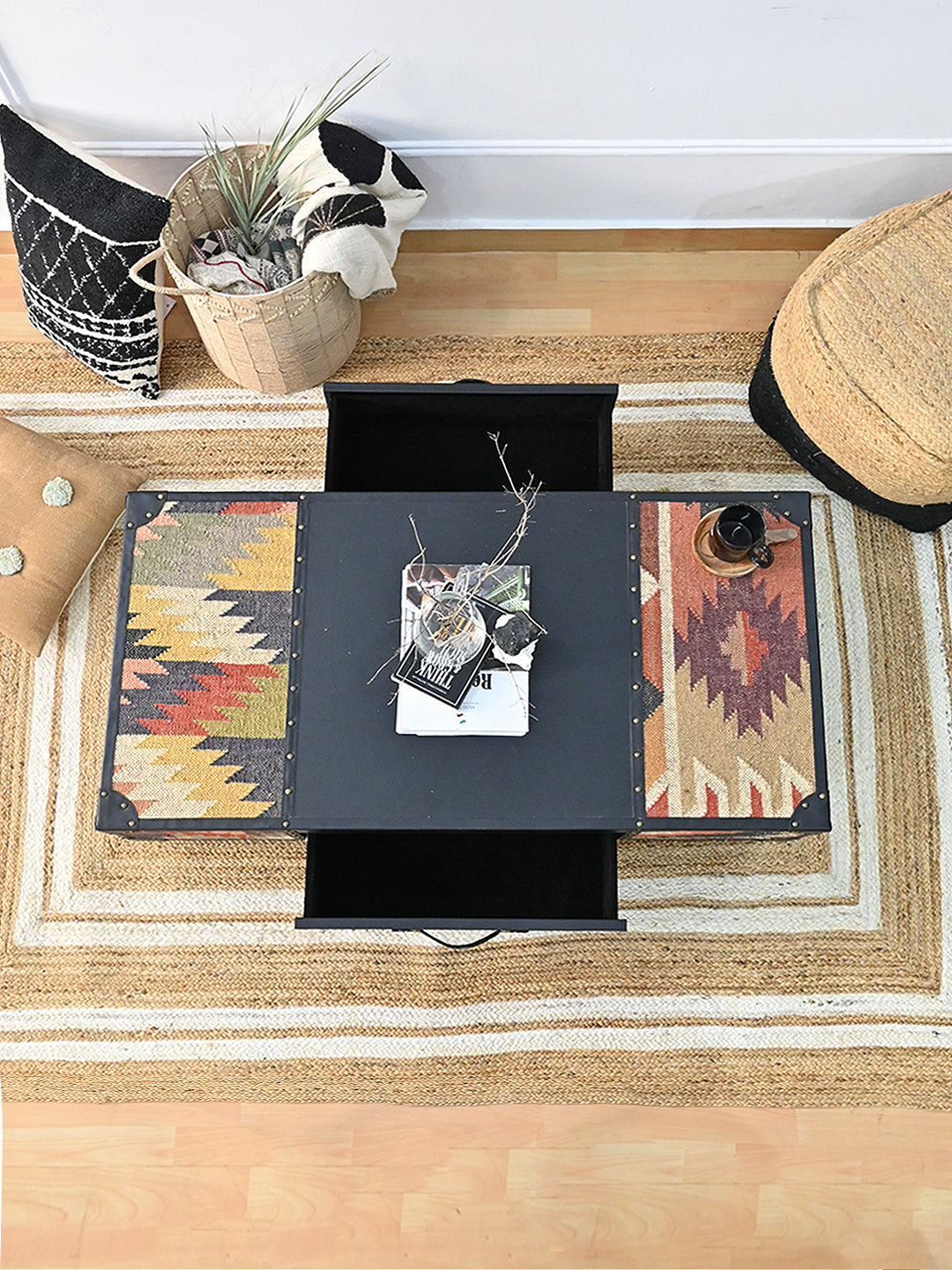 Overhead styled view of the Kumbhalgarh coffee table with both drawers open on a striped jute rug