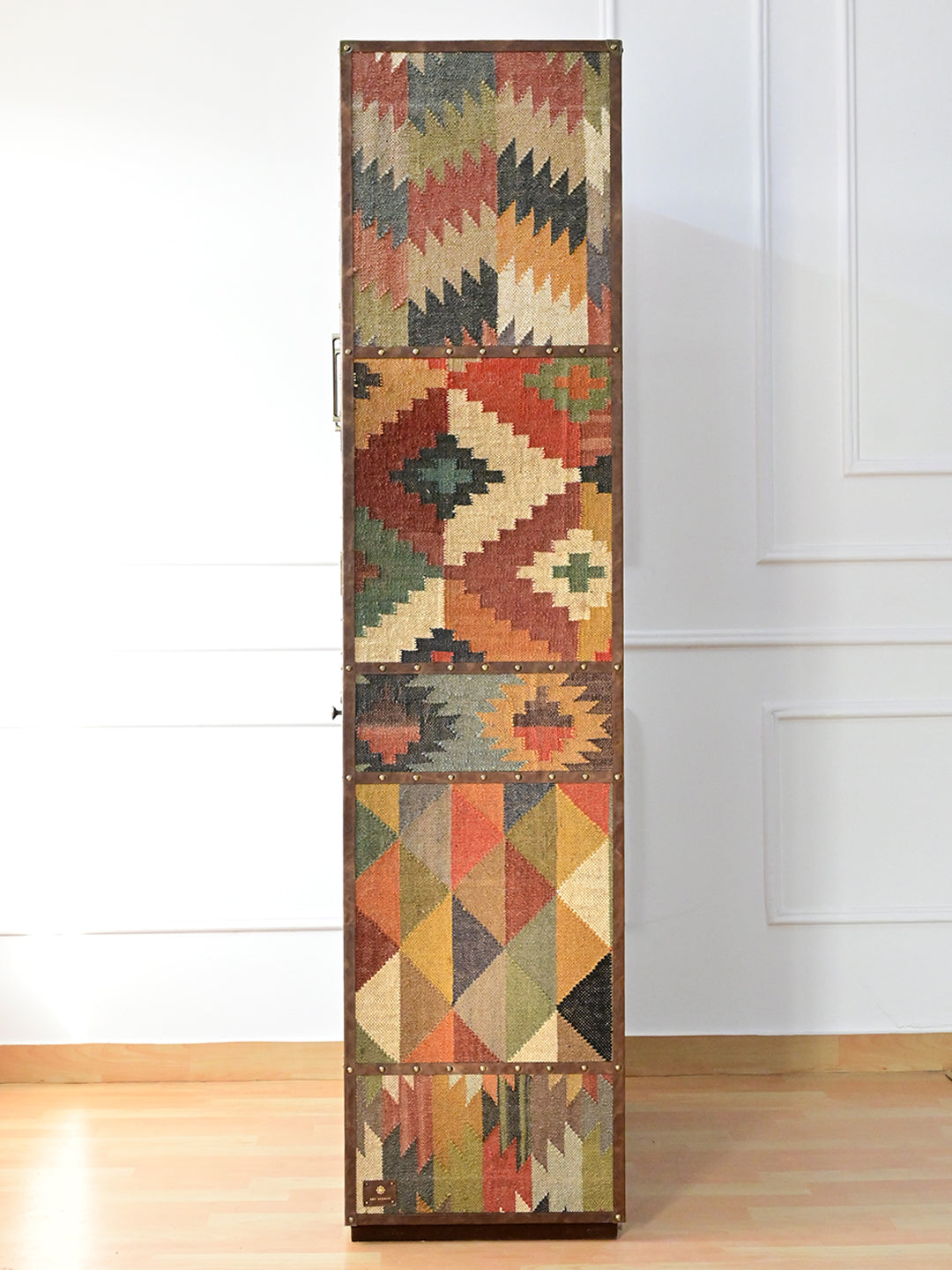 Side elevation of the Alsisar wardrobe showing five stacked kilim panels divided by leather rails
