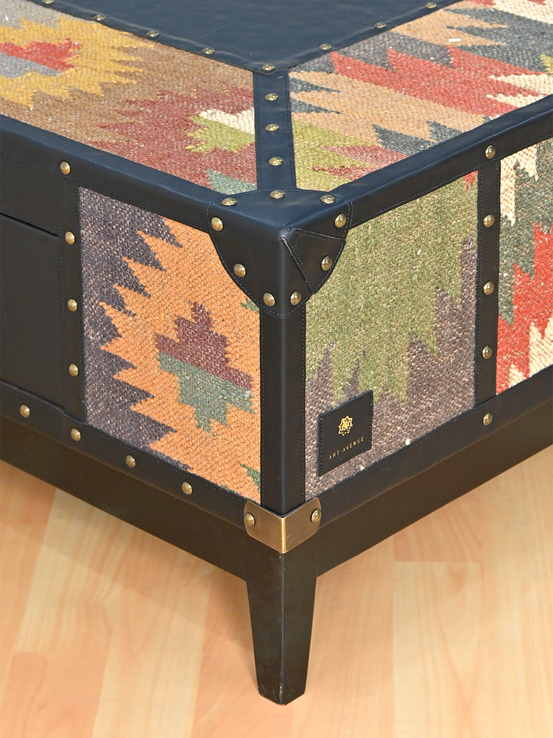 Corner of the Mehrangarh coffee table with the Art Avenue leather badge and brass base cap, made to order