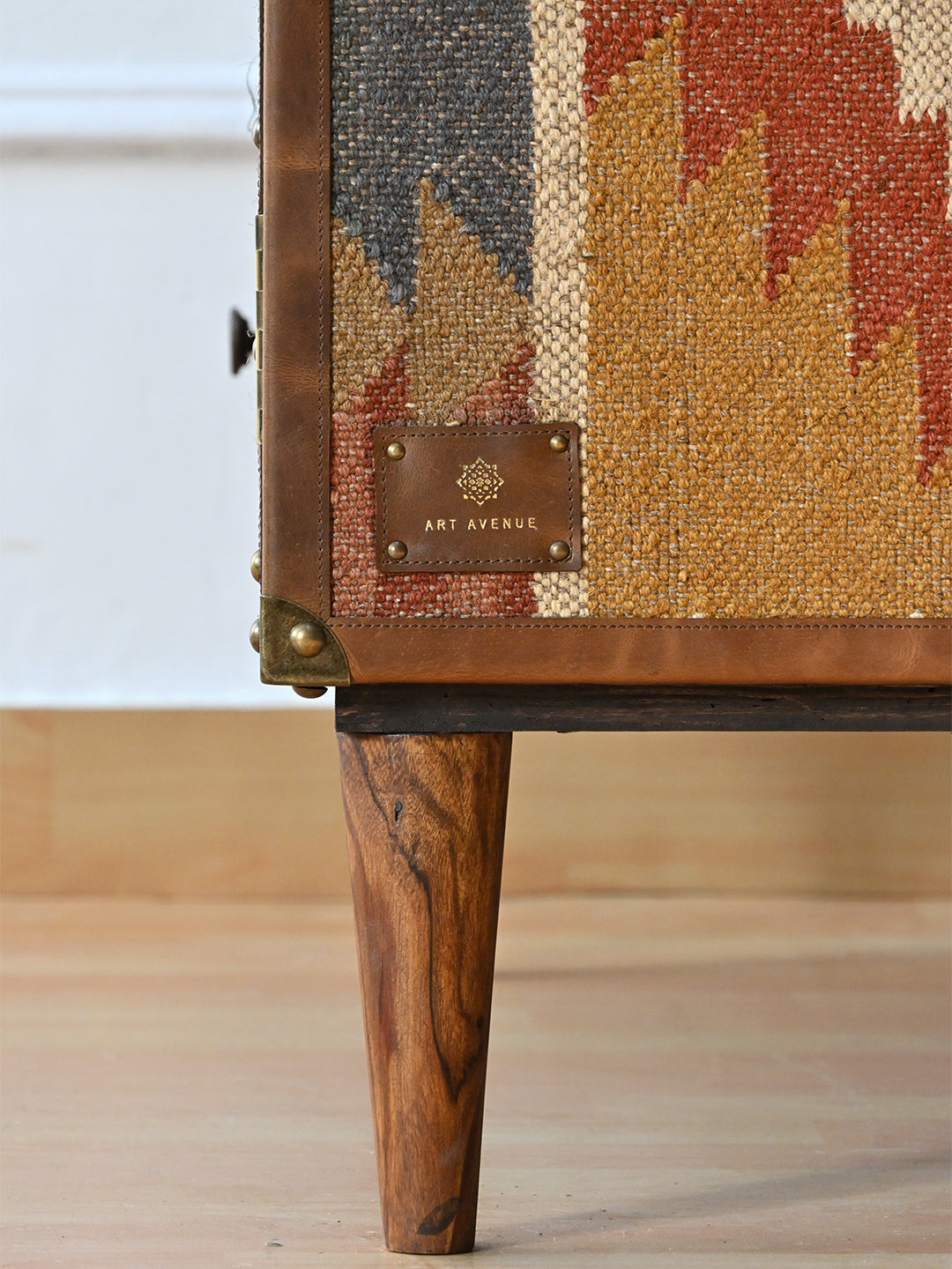 Stitched Art Avenue leather maker's tag on the kilim side of the Kanota sideboard, with tapered wooden leg