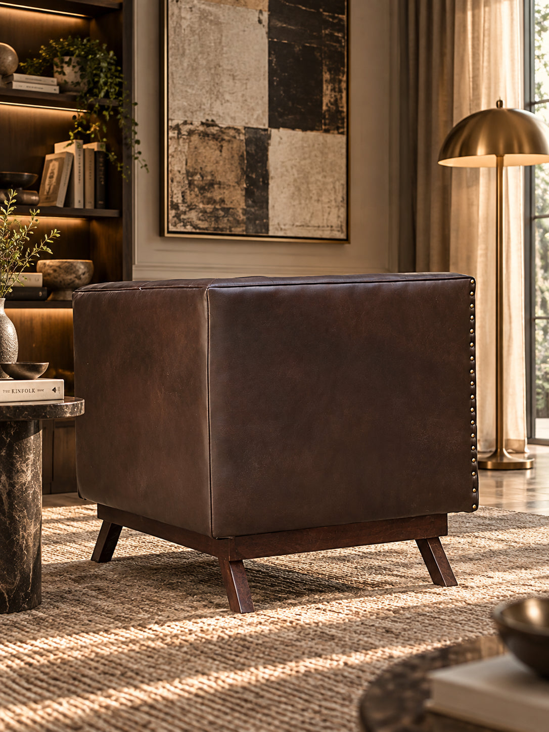 Chail buttoned leather club chair from behind, showing the hand-driven brass stud line down the plain outside arm — Art Avenue, made to order