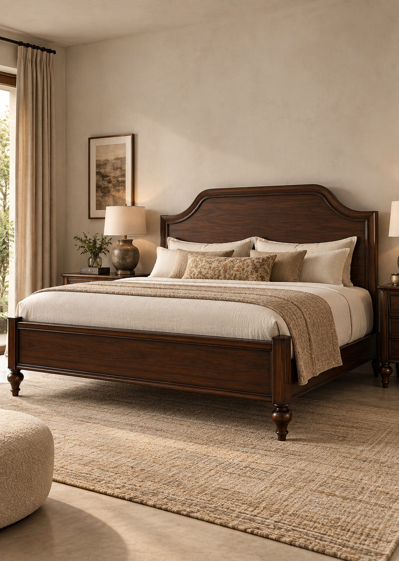 Darjeeling Colonial Bed with wood panel headboard in Walnut, in a sunlit bedroom — tall arched headboard in a moulded frame, low panelled footboard and turned feet. Art Avenue, made to order.