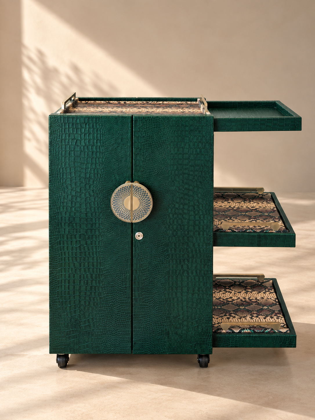 Front view of the Panjim Leather Rolling Bar Cabinet: locking twin doors with round brass medallion pull and three side shelves holding removable python-print leather trays — Art Avenue, made to order