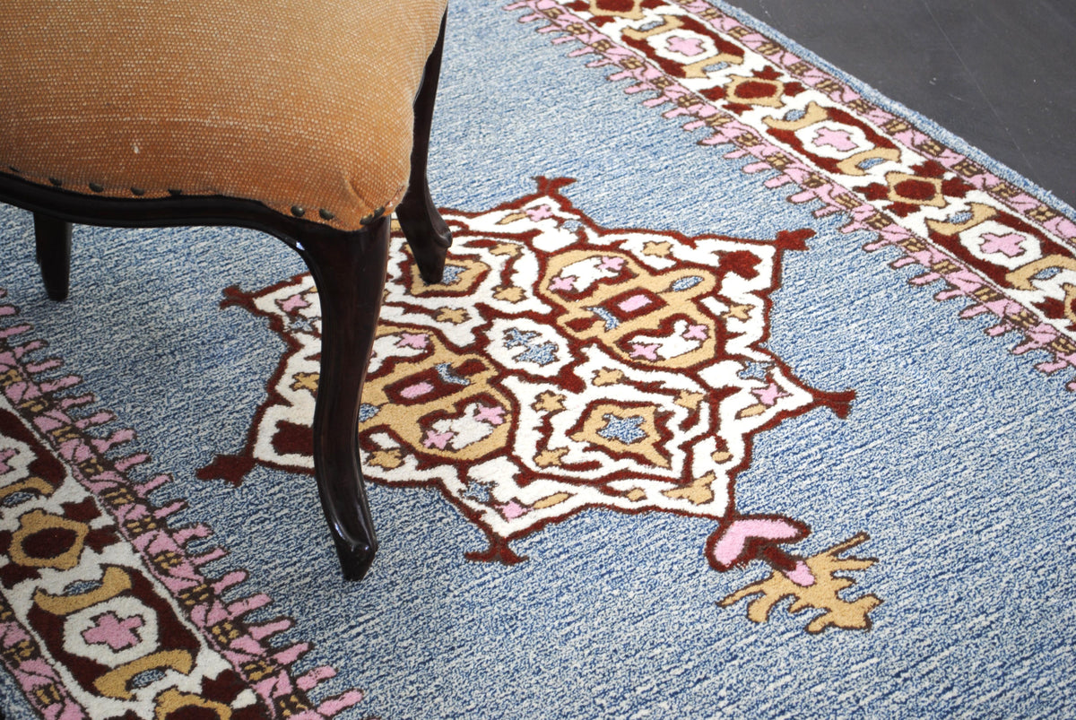 Lucknow hand-tufted wool rug with a chair, landscape view of the medallion and border in a room setting, Art Avenue