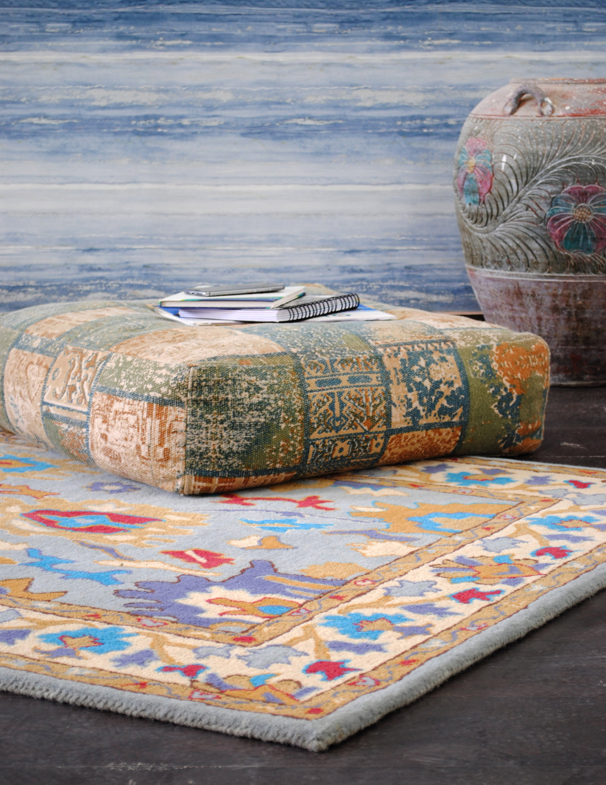 Agra hand-tufted wool rug styled with a patchwork floor cushion and carved terracotta urn