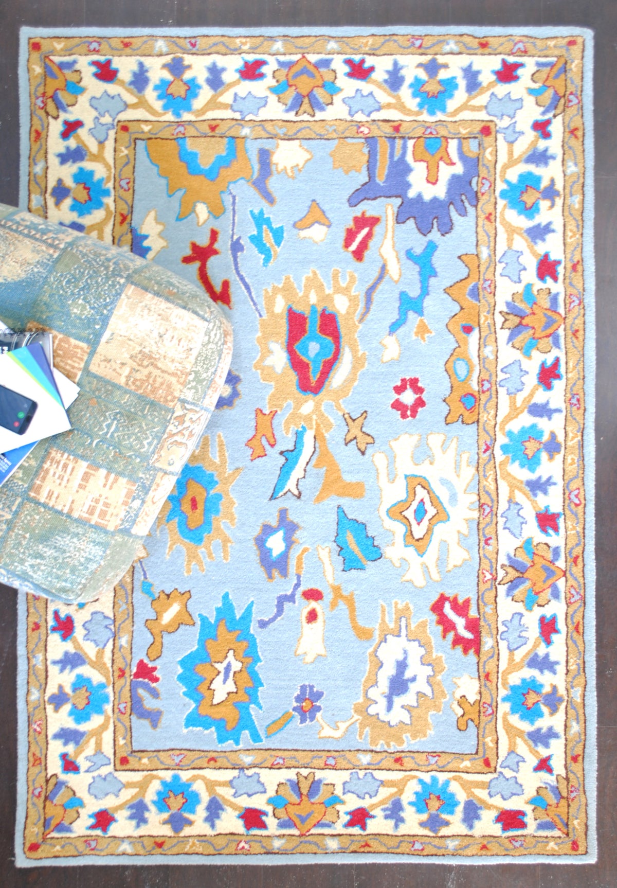 Overhead view of the Agra 4x6 ft rug with a floor cushion resting on one corner