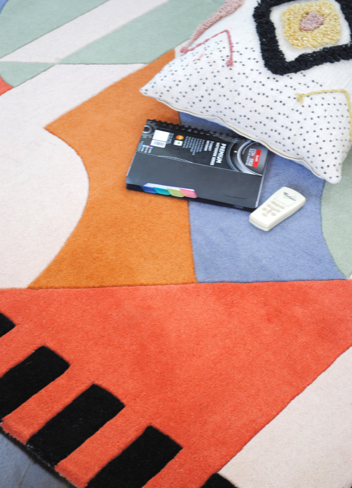 Detail of the Goa rug's coral field and black bars beside burnt orange and sky-blue blocks, Art Avenue