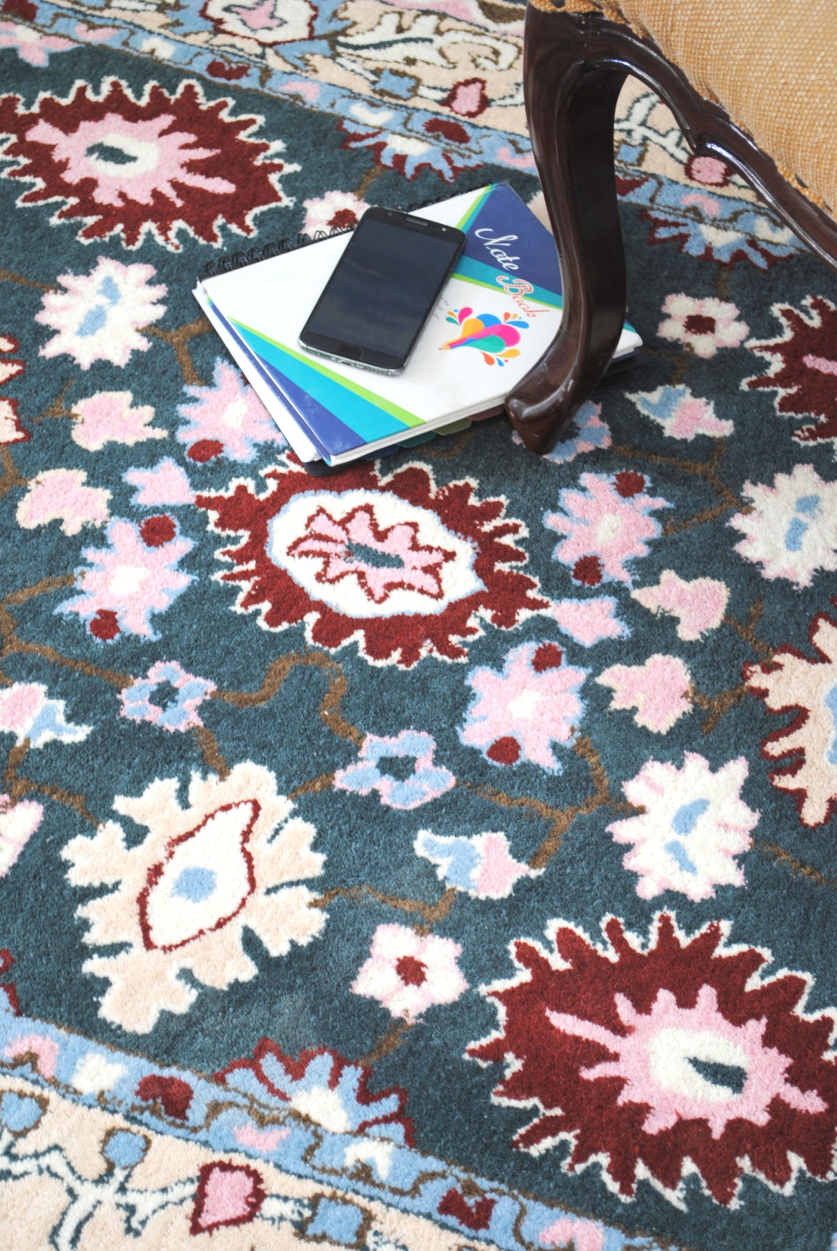 Close view of the Srinagar rug pattern: crimson rosettes and rose, ivory and sky-blue flowers joined by golden-brown stems