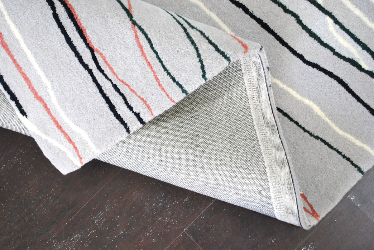 Edge of the Chilika rug: dense sheared New Zealand wool pile and grey wool-bound edge, no fringe