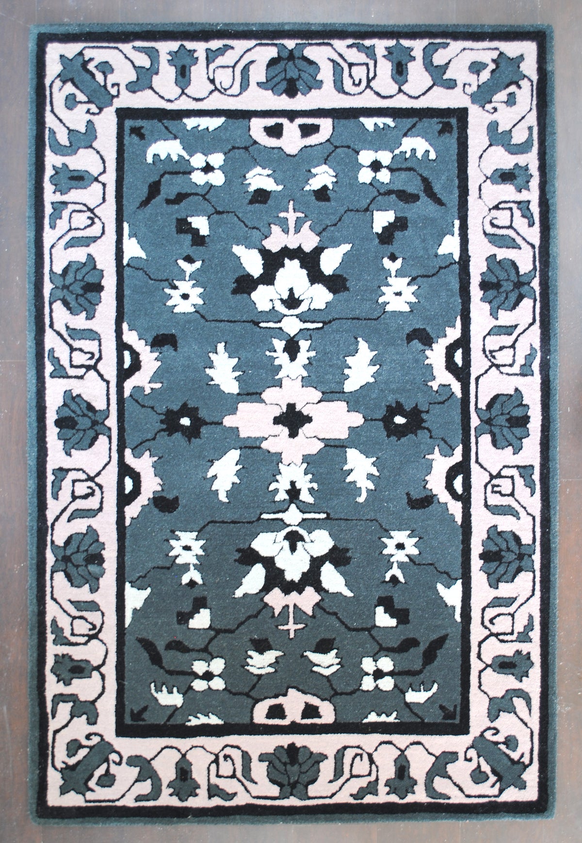 Shimla hand-tufted rug in 100% New Zealand wool, full overhead view: mirrored ivory and blush blossoms on a slate grey field with a wide blush scrolling-vine border, Art Avenue, 4×6 ft