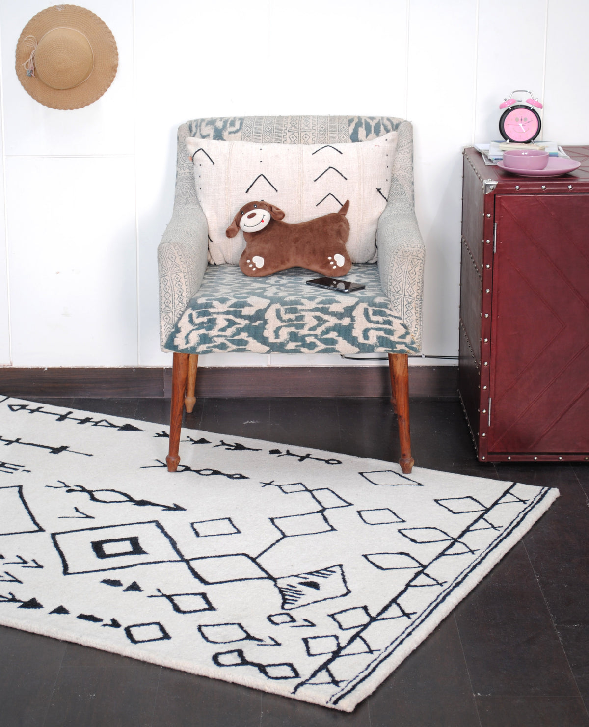 Spiti Hand-Tufted Rug under an upholstered armchair beside a leather trunk, black and ivory Berber design — Art Avenue