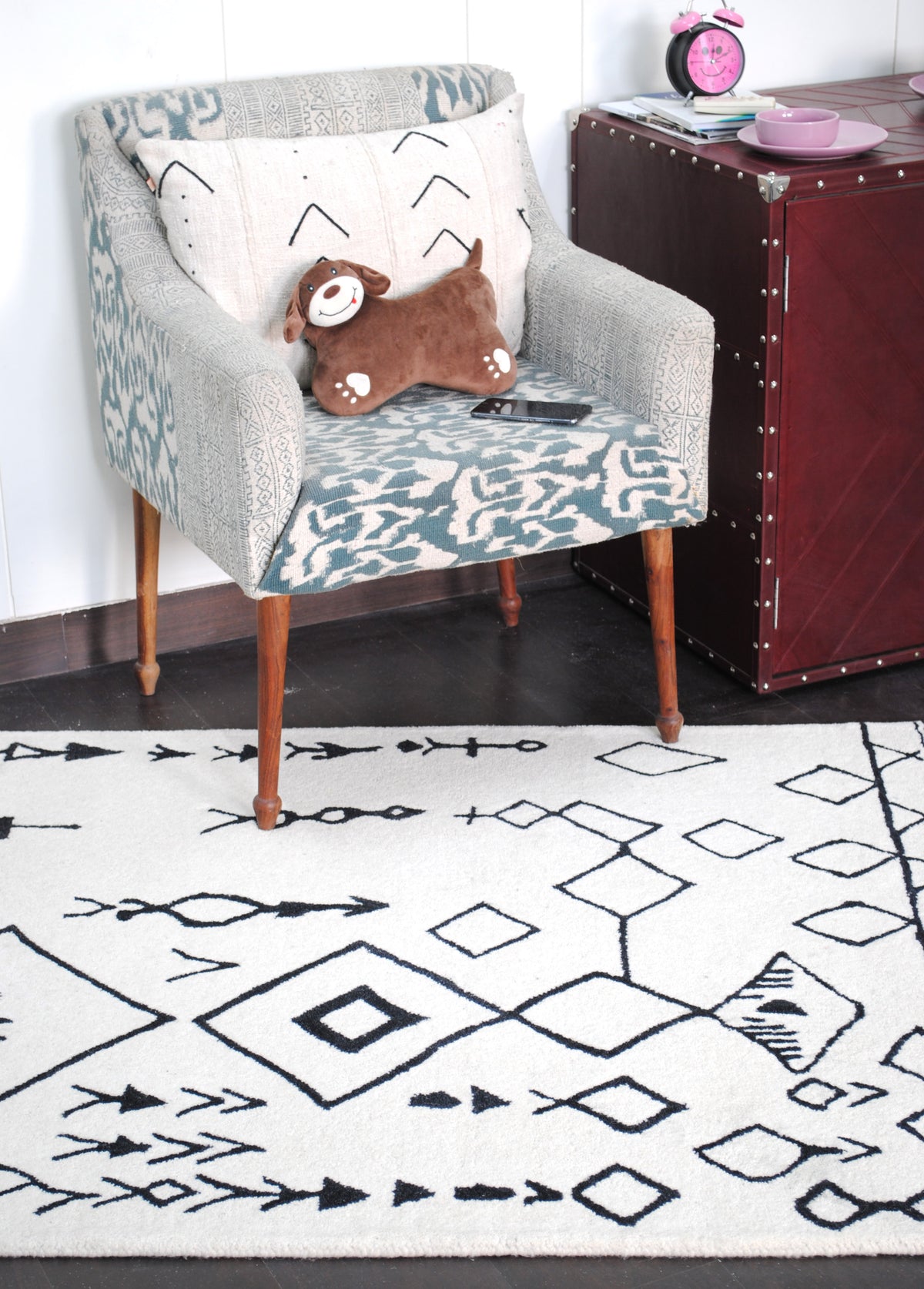 Closer room view of the Spiti Hand-Tufted Rug with diamond chain and arrow motifs on a dark wood floor — Art Avenue