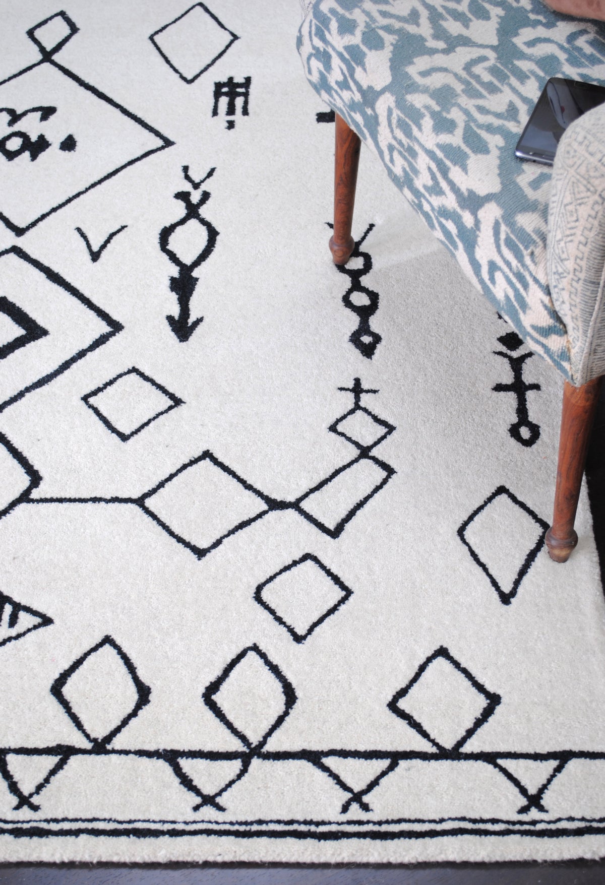 Close view from above of the Spiti Hand-Tufted Rug, black beaded totems and diamonds in dense ivory wool pile — Art Avenue