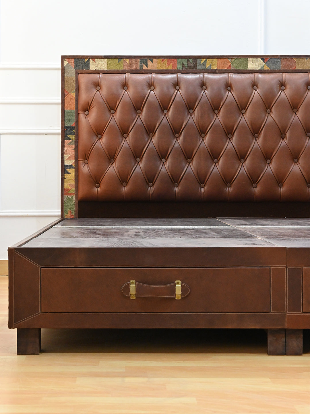 Narlai kilim and leather storage bed by Art Avenue, made to order — detail of the leather strap drawer pull with brass keeper