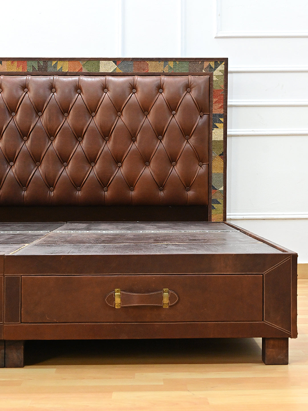 Narlai kilim and leather storage bed by Art Avenue, made to order — close view of headboard corner above the foot drawer