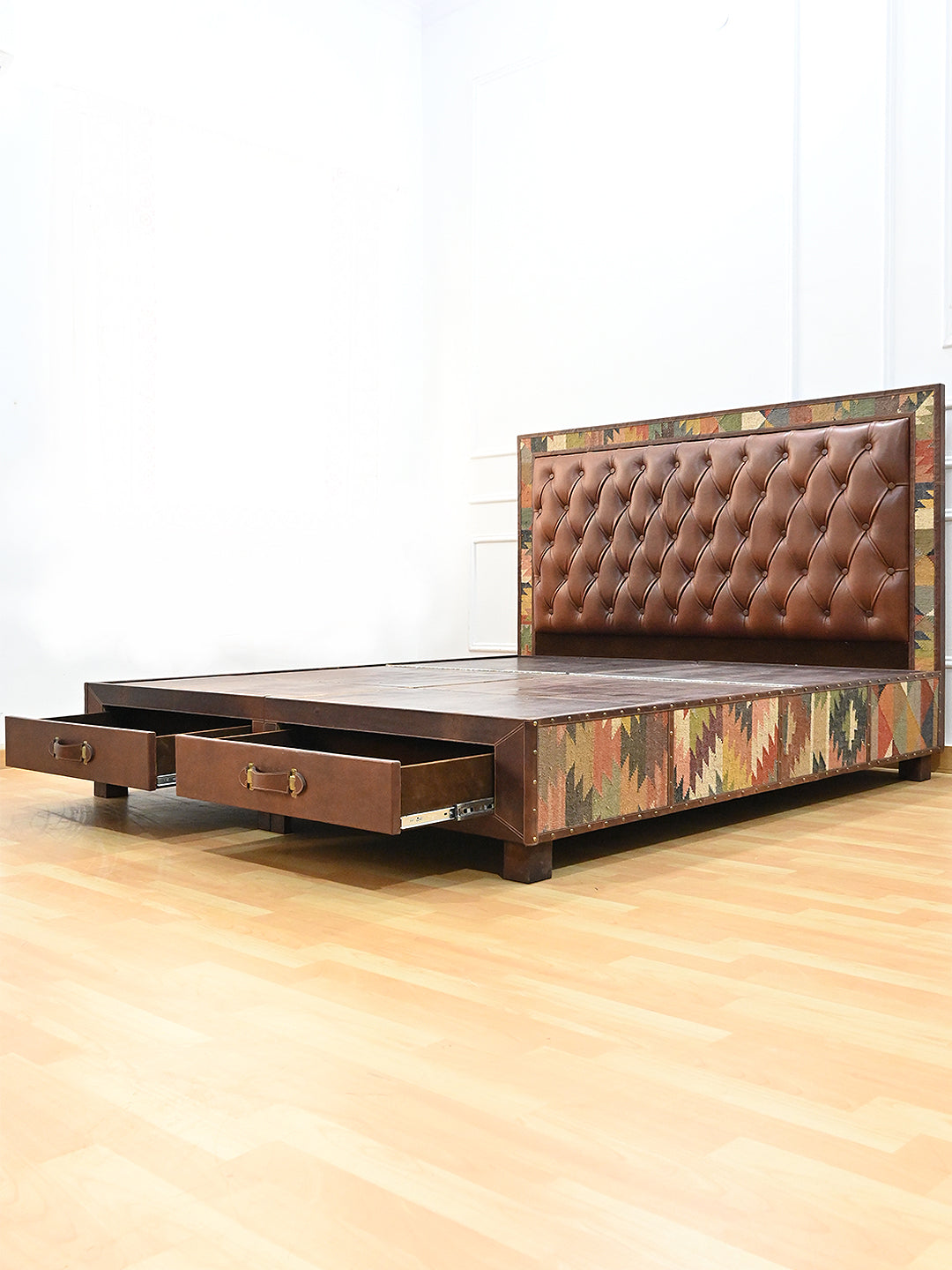 Narlai kilim and leather storage bed by Art Avenue, made to order — three-quarter view with both foot drawers pulled open